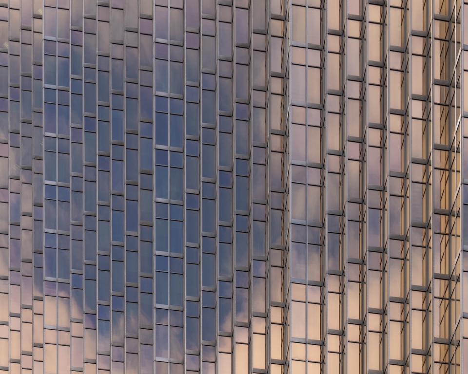 Blue sky and white clouds reflecting on rosegold facade